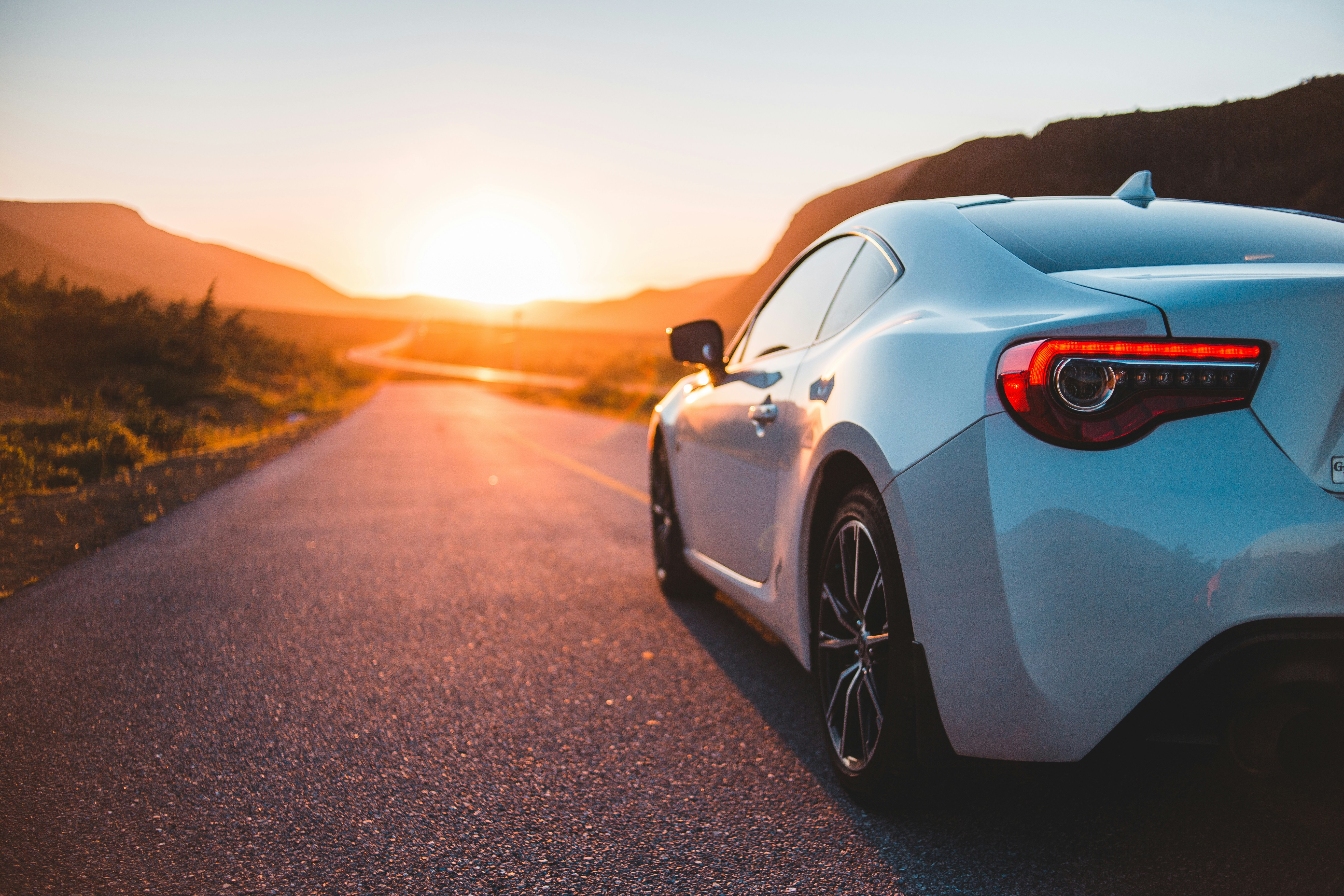 Car on an open road at sunset