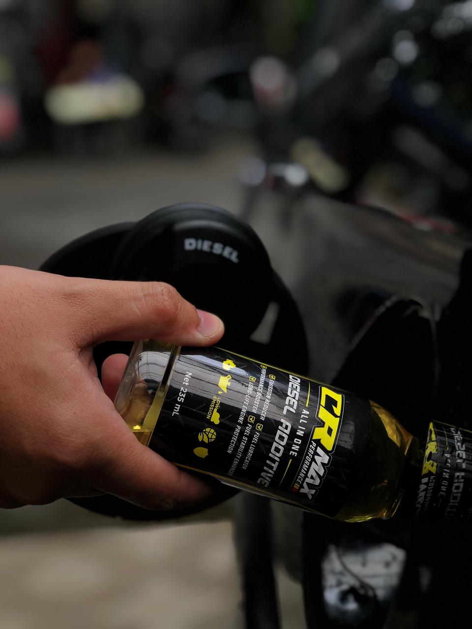 Pouring CRMax Diesel Additive into a fuel tank
